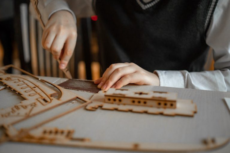 a-boy-in-school-uniform-makes-a-3d wooden puzzles 2023-11-27-05-10-19-utc