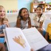 The Top 10 Children's Books of 2024 on amazon - emale Primary Or Elementary School Teacher Reads Story To Multi-Cultural Class Seated In Classroom