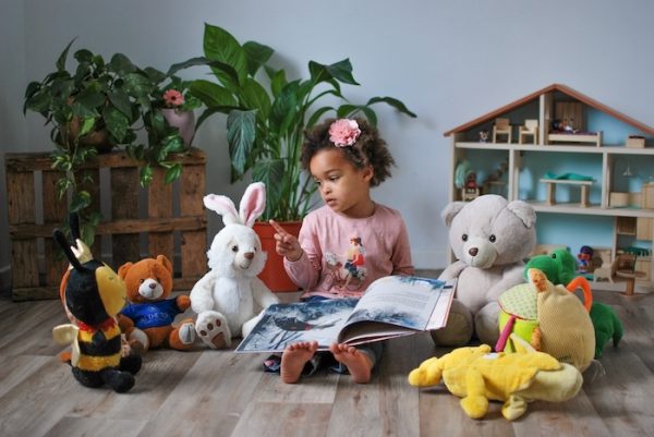 Little 2 year old girl reading one of the Top 10 Books For Kids Aged 2: Essential Reads For Little Ones